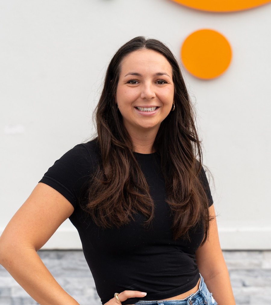 Alex Bridges, Administrative Assistant at Florida Family Pools, smiling in front of a colorful backdrop, showcasing the team’s family-oriented approach to pool construction services.