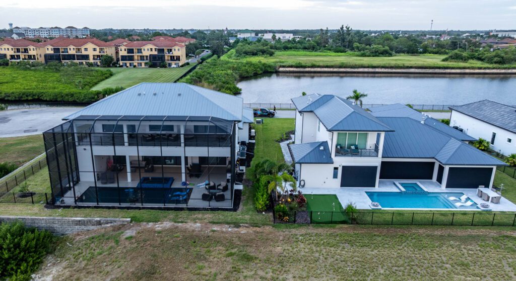 Aerial view of modern homes featuring a screened pool area and private swimming pool, showcasing Florida Family Pools' custom pool designs and landscaping.