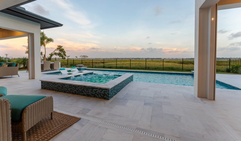 Luxury pool design featuring a spa, modern seating area, and expansive outdoor view, showcasing Florida Family Pools' custom pool construction expertise.